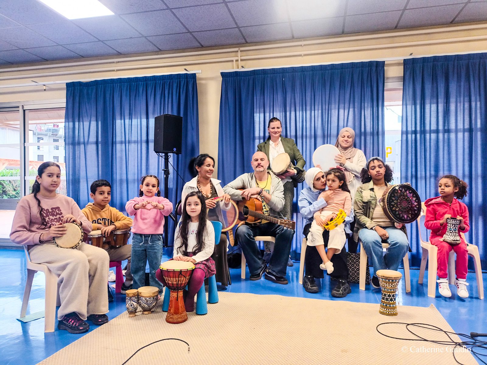 Portrait de groupe d'un atelier en famille avec enfants, parents et intervenants
